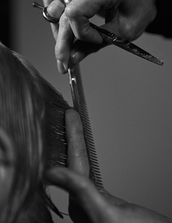 Cosmetology students working hands-on in beauty school clinic floor
