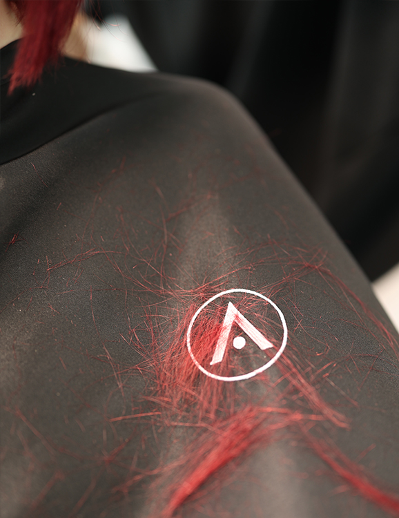 Students gaining real salon experience in beauty school. Hair on Aveda Arts Apron.