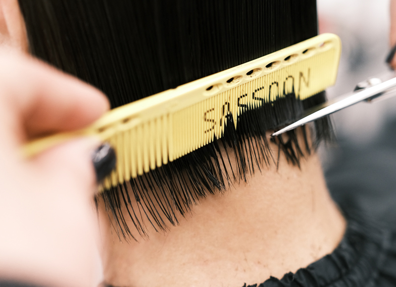 Close-up of comb and scissor precision cutting technique inspired by Sassoon Connect methodology
