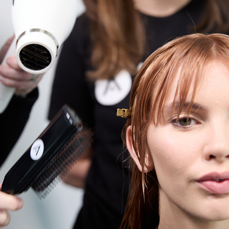 Cosmetology student providing a guest service experience while building consultation, communication, and professional hairstylist skills