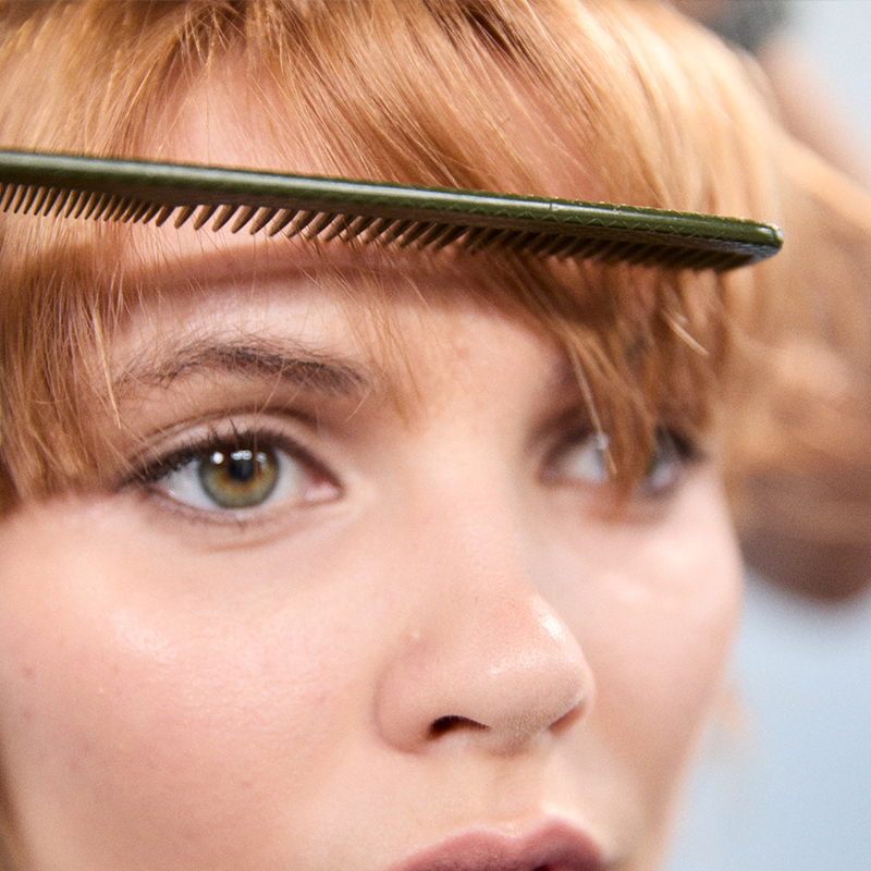 Aveda Arts cosmetology student learning professional haircutting skills through hands-on beauty school training