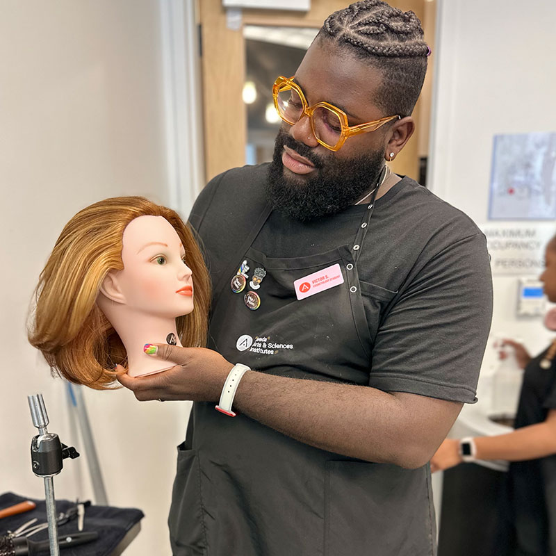 Victor Anthony beauty school student showing off mannequin work