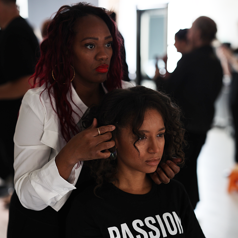 Aveda Arts student and educator practicing textured hair styling techniques
